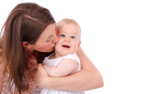Foto de una mamá dando un beso a su bebé.